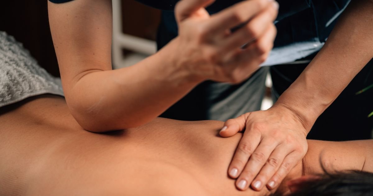 girl getting deep tissue massage from a therapist who is kneeding her back